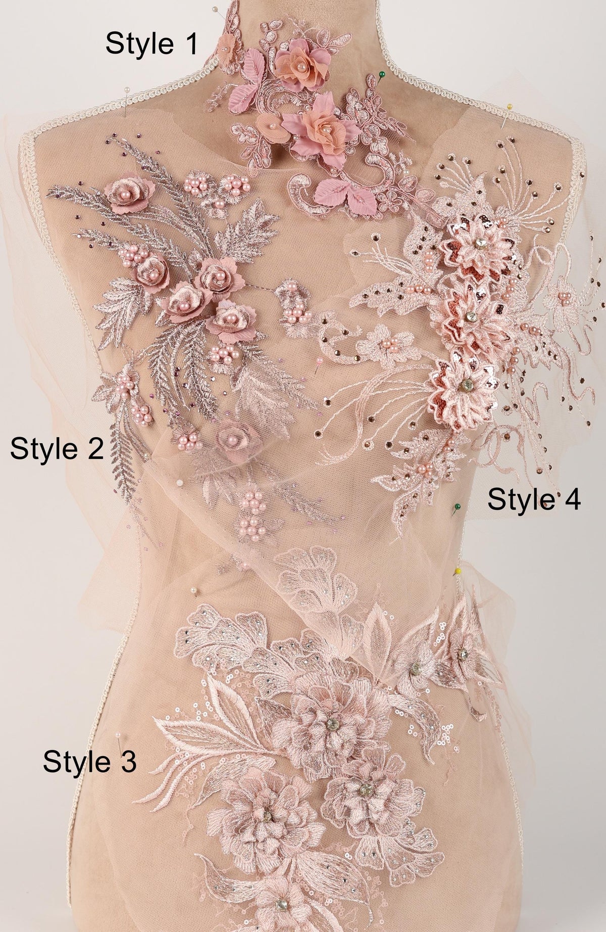A mannequin with a beige dress adorned with intricate floral embroidery in shades of pink and white.