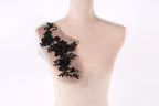 A mannequin with a decorative black lace piece on its shoulder.