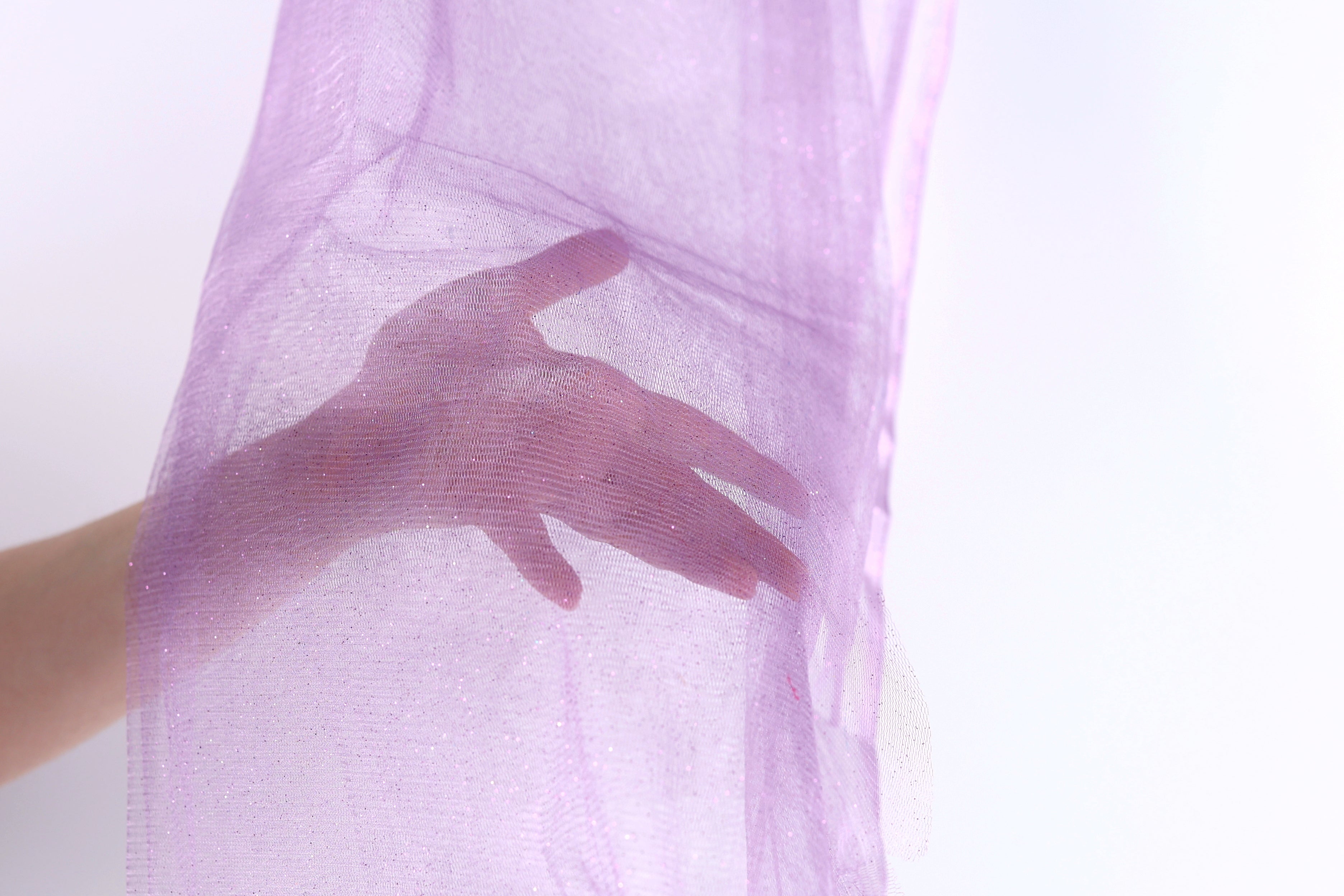 A hand is holding a purple fabric or material, partially obscuring the viewer's view.