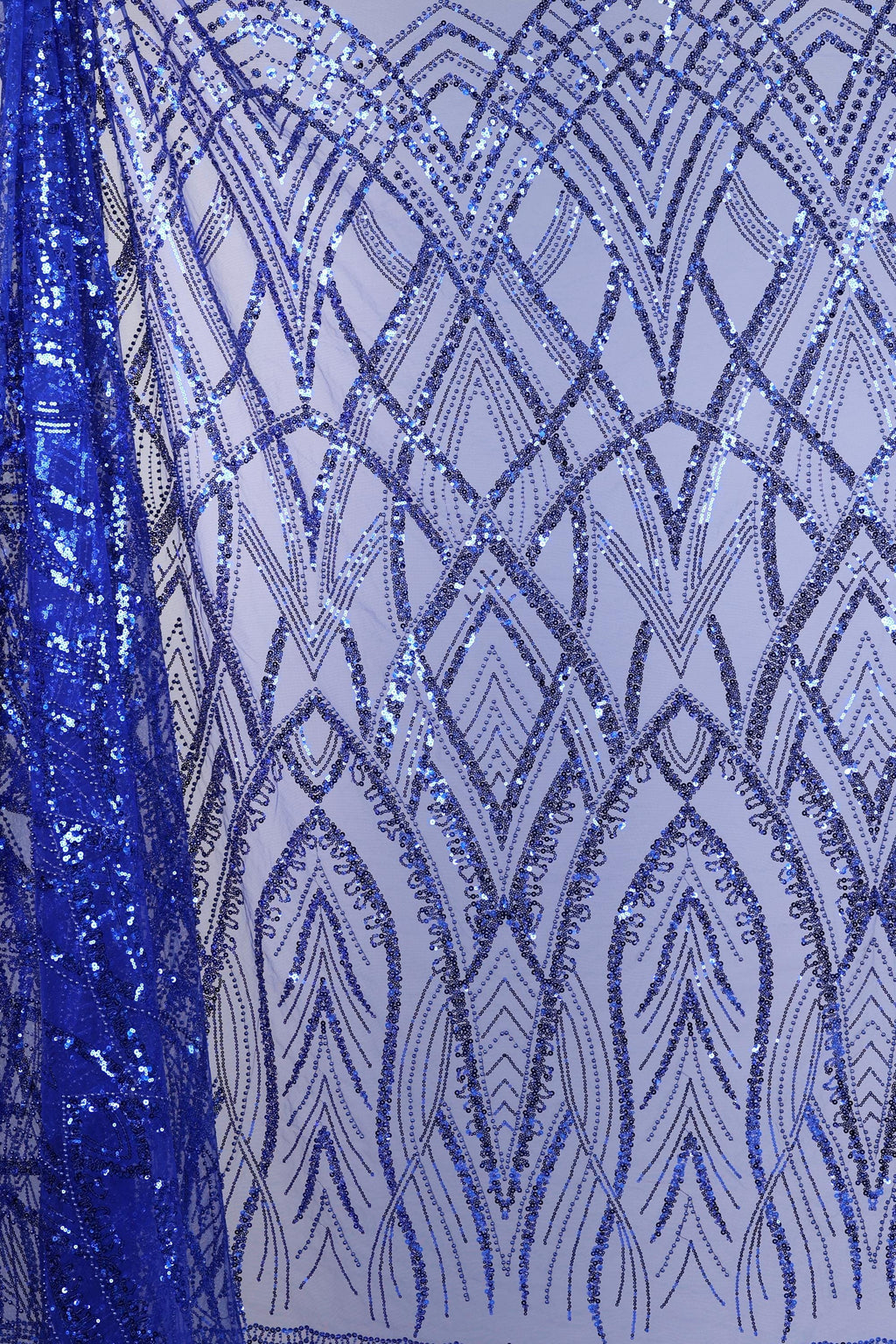 a close-up view of a fabric with a striking pattern of blue sequins and lines. The fabric appears to be a sheer material, with the blue sequins creating a visually appealing and intricate design. The pattern on the fabric is complex and detailed, with the sequins and lines forming a repeating pattern that covers the entire fabric. The image does not contain any text or other discernible objects, and the focus is solely on the fabric and its design.