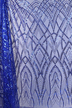 a close-up view of a fabric with a striking pattern of blue sequins and lines. The fabric appears to be a sheer material, with the blue sequins creating a visually appealing and intricate design. The pattern on the fabric is complex and detailed, with the sequins and lines forming a repeating pattern that covers the entire fabric. The image does not contain any text or other discernible objects, and the focus is solely on the fabric and its design.
