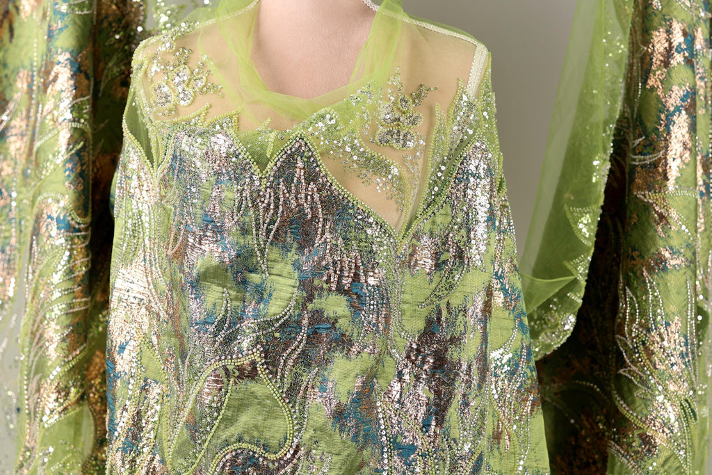 a close-up view of a green and silver sequined dress or garment, with intricate patterns and designs.