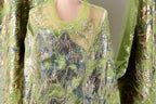 a close-up view of a green and silver sequined dress or garment, with intricate patterns and designs.