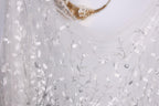 a white fabric with a delicate, leaf-like pattern, creating a soft and elegant appearance.