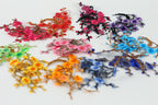 A collection of colorful artificial flowers and branches in various shades of pink, red, purple, blue, and yellow, arranged in a visually appealing manner.