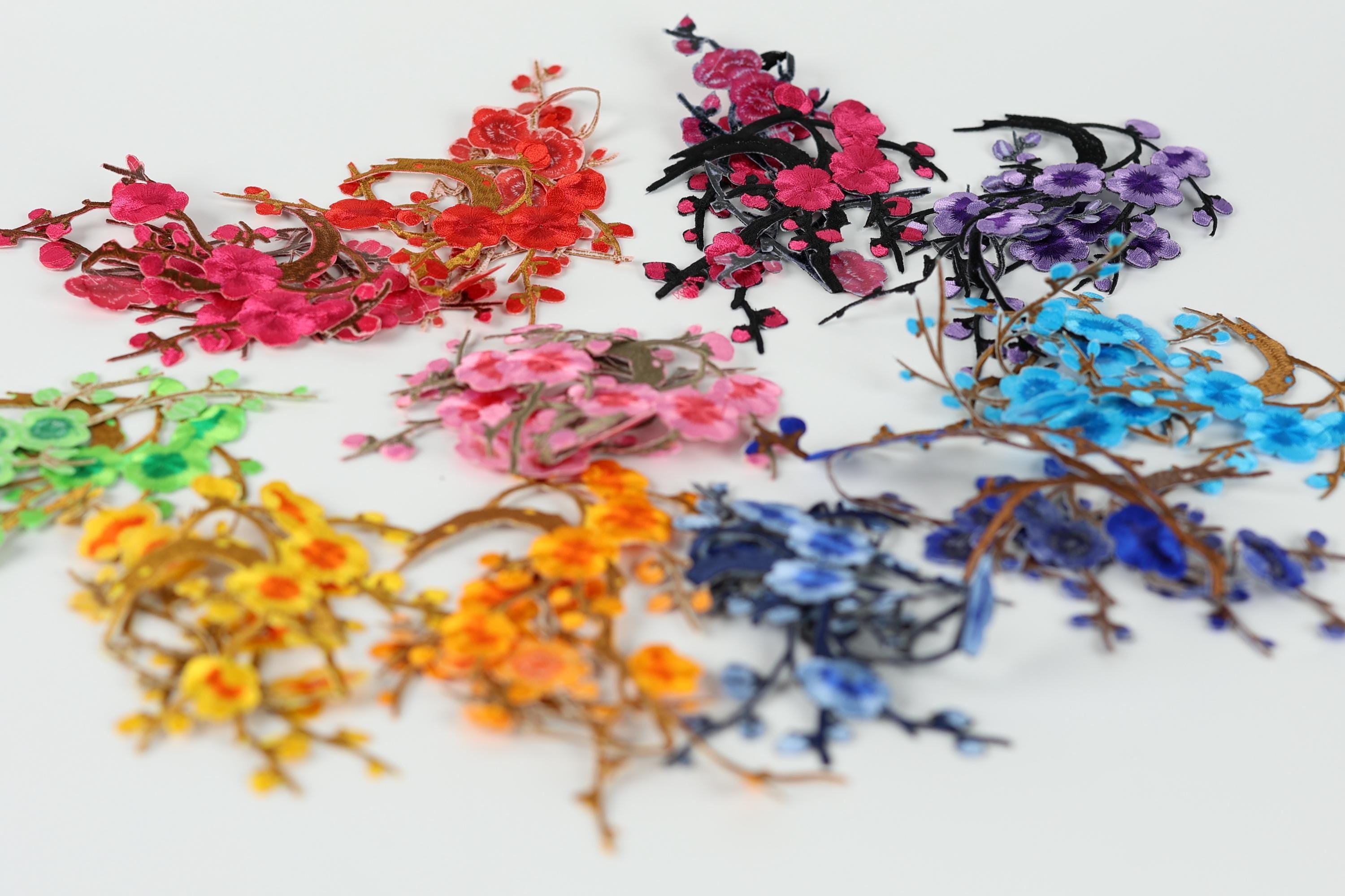 A collection of colorful artificial flowers and branches in various shades of pink, red, purple, blue, and yellow, arranged in a visually appealing manner.