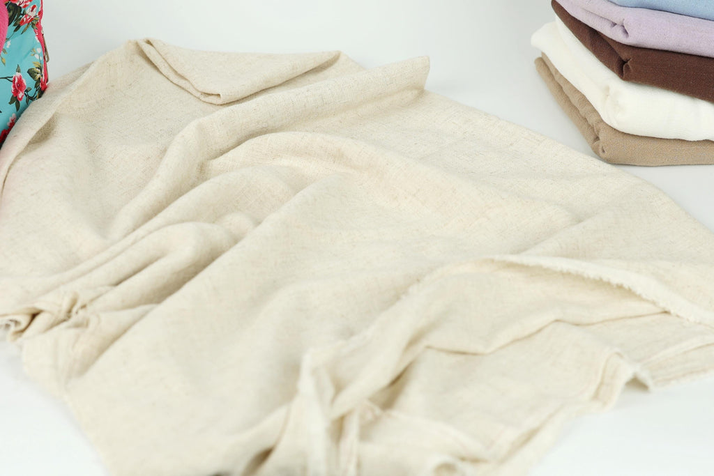 A pile of folded, light-colored fabric, possibly a blanket or towel, is the main focus of the image.