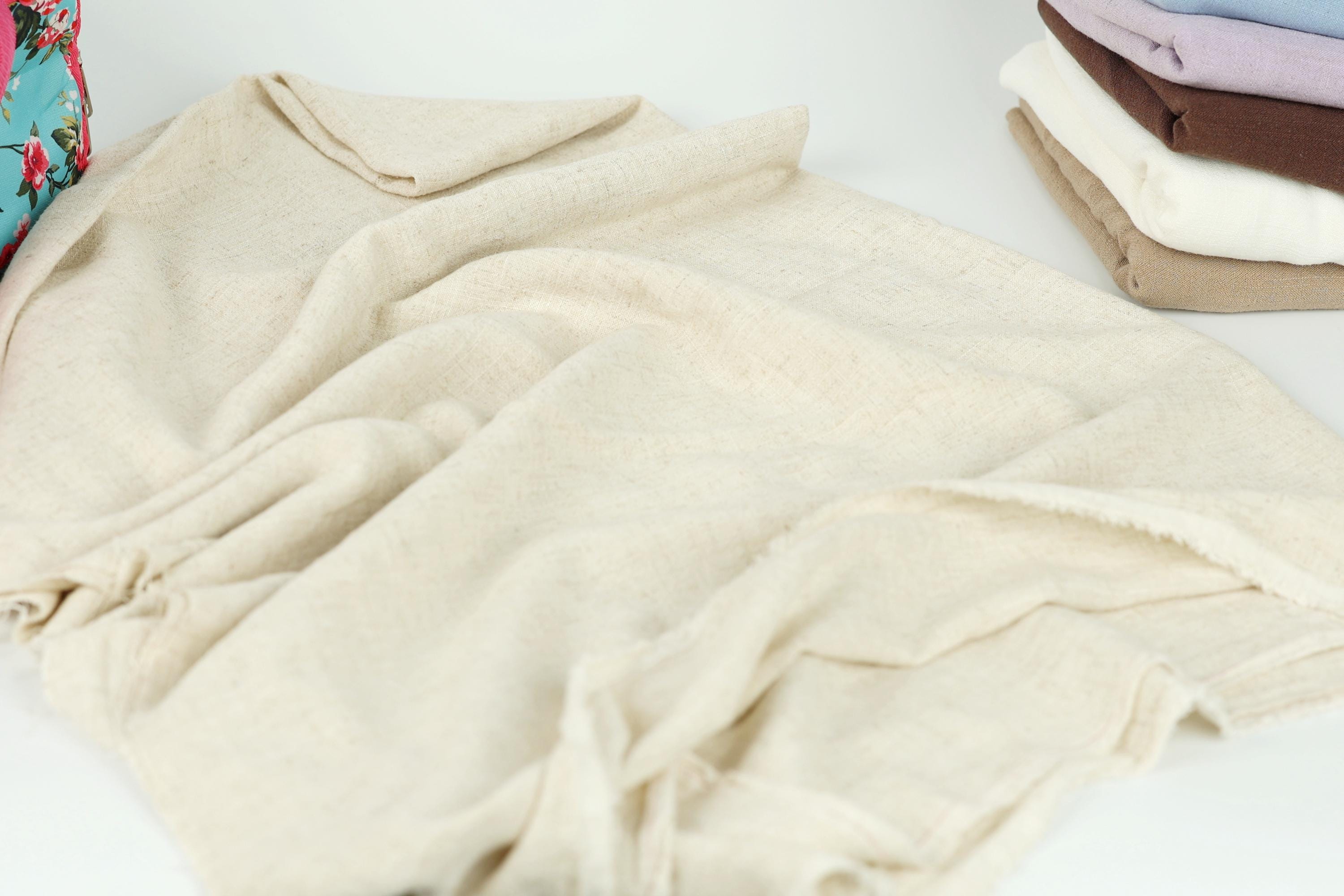 A pile of folded, light-colored fabric, possibly a blanket or towel, is the main focus of the image.