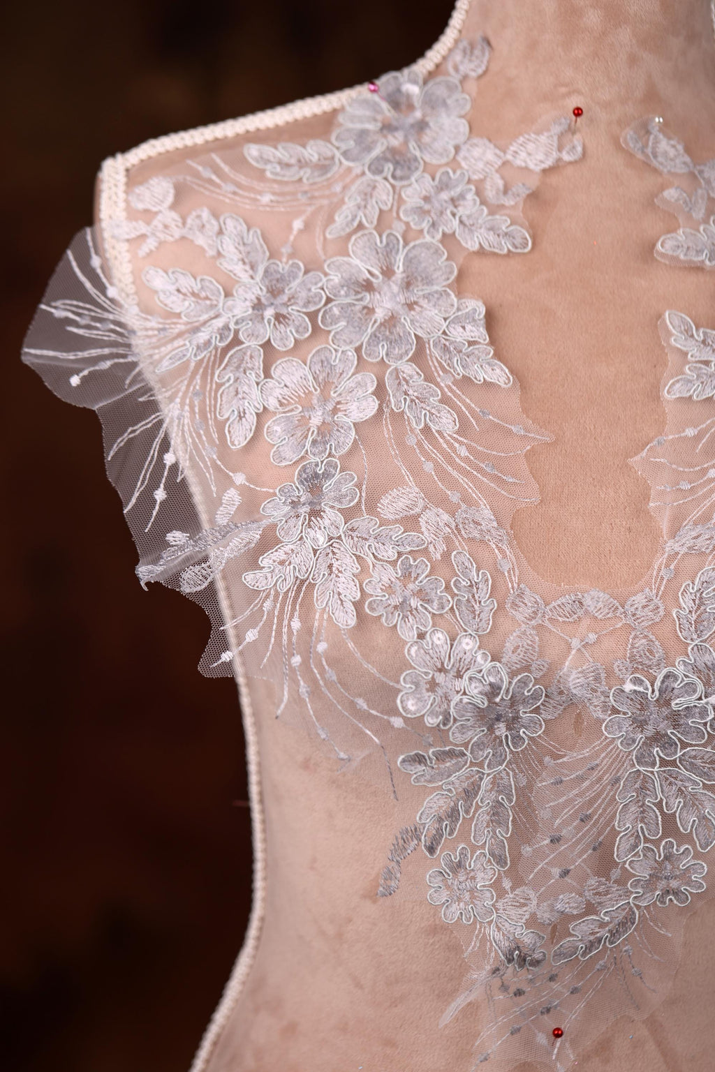 a white dress with flowers on a mannequin