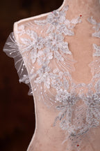 a white dress with flowers on a mannequin