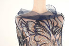 A mannequin wearing a dress with a sheer, sequined bodice and a blue, sheer, floral-patterned collar.