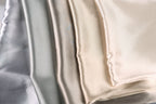 a close-up view of a collection of fabric swatches in various shades of gray, beige, and white.
