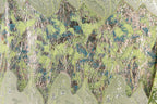 The image is a close-up of a fabric with a vibrant, multicolored pattern. The fabric appears to be made of a shiny, metallic material, with a mix of green, blue, and silver colors. The pattern is intricate and detailed, with various shapes and textures that create a visually striking and dynamic design.