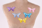 a mannequin torso with six colorful butterfly patches on it, each with a different color and design.