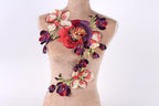 A mannequin torso with a decorative floral embroidered patch on it.