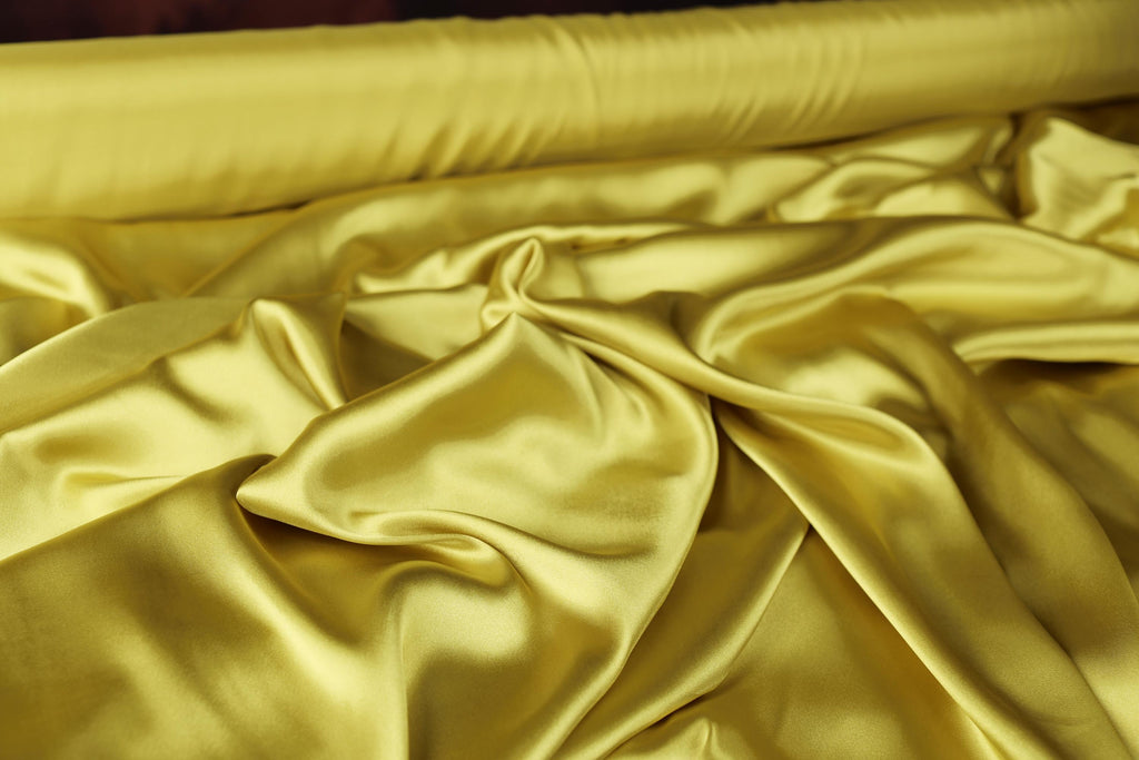 a close up of a bed with a yellow comforter
