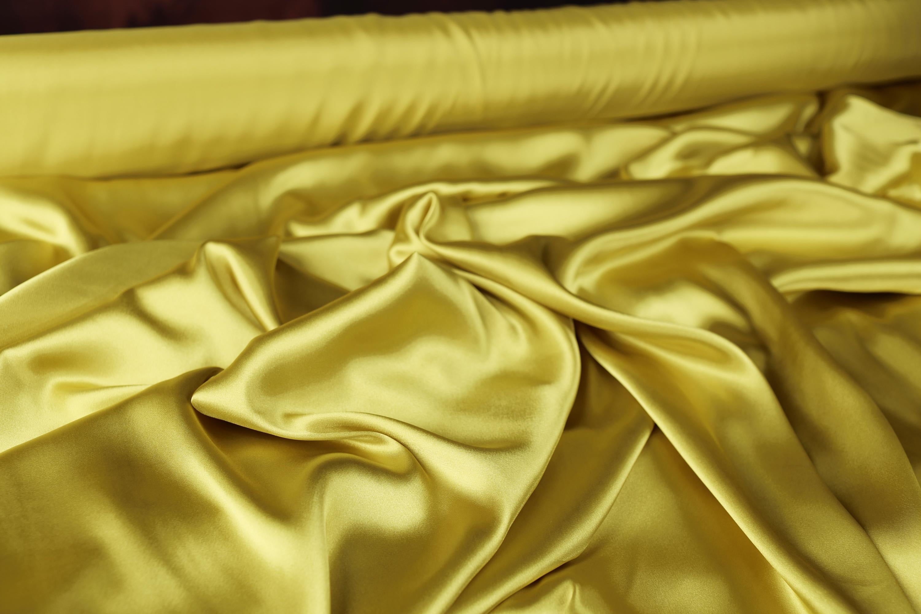 a close up of a bed with a yellow comforter