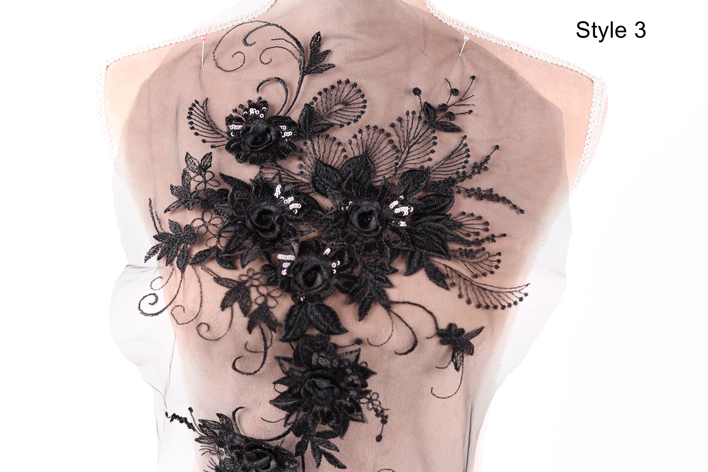 a close-up view of a delicate, intricate black lace design on the back of a dress or garment.