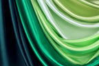 a close-up view of a collection of colorful satin fabric, with a gradient of green and blue hues. The fabric appears to be folded or draped in a way that creates a visually striking and textured effect.