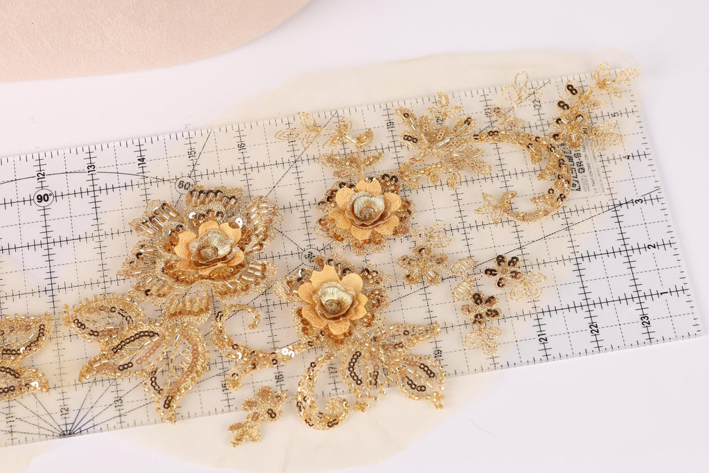 a close-up view of a piece of fabric with intricate gold embroidery and floral designs.