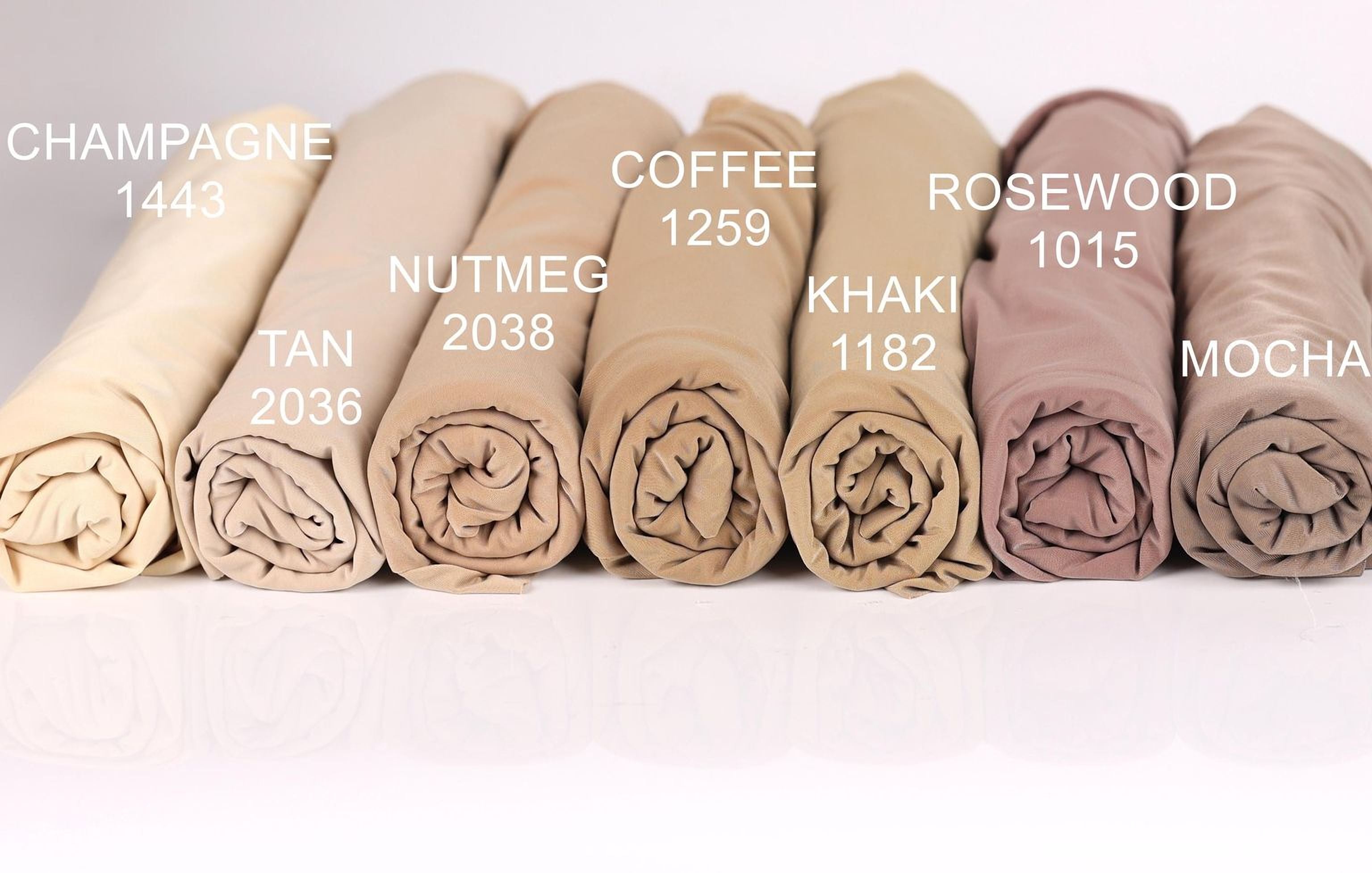 a collection of rolled-up fabric swatches in various colors, including champagne, coffee, rosewood, khaki, tan, and mocha.