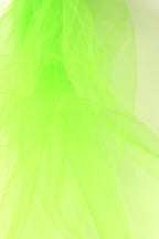 The image is a close-up of a green, translucent material, possibly a type of fabric or paper, with a soft, flowing texture. The color is bright and vibrant, creating a visually striking contrast against the light background.