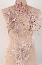 A mannequin wearing a dress with intricate floral embroidery and lace details.