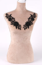 A mannequin with a beige body and black floral embroidery on the bust area.