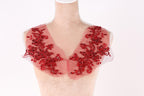 A mannequin wearing a red, sheer collar with intricate floral embroidery.