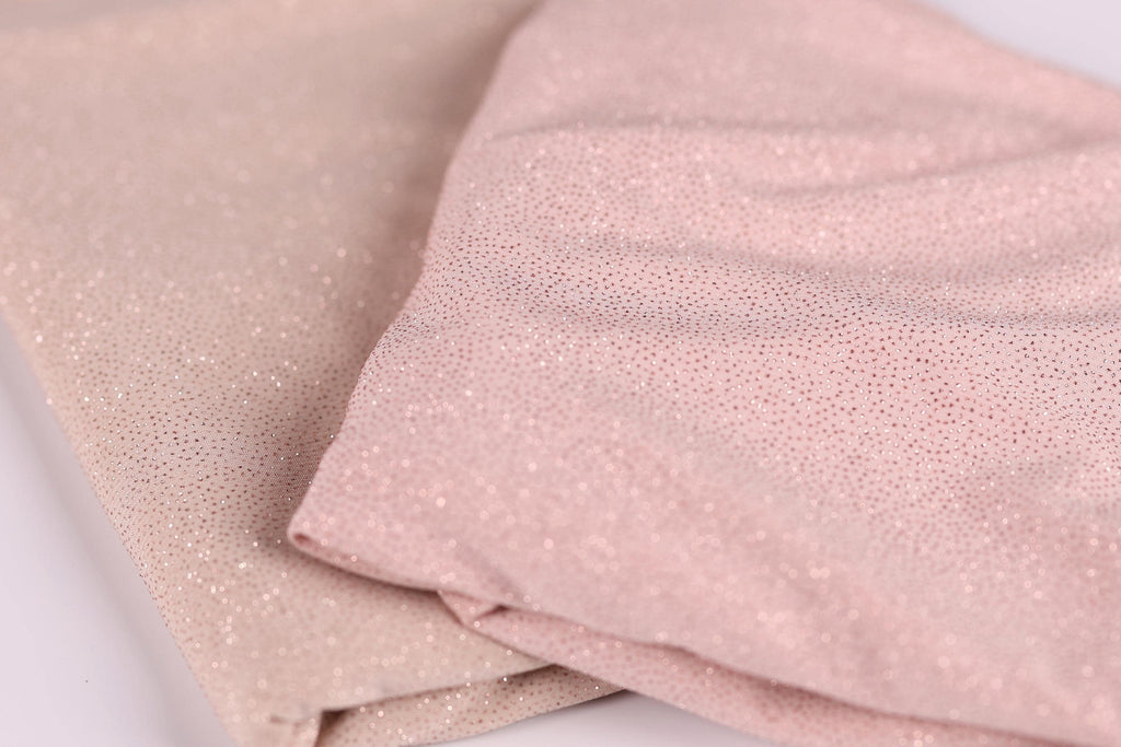 two pieces of fabric, one in a light pink color and the other in a darker pink color, both with a glittery texture.