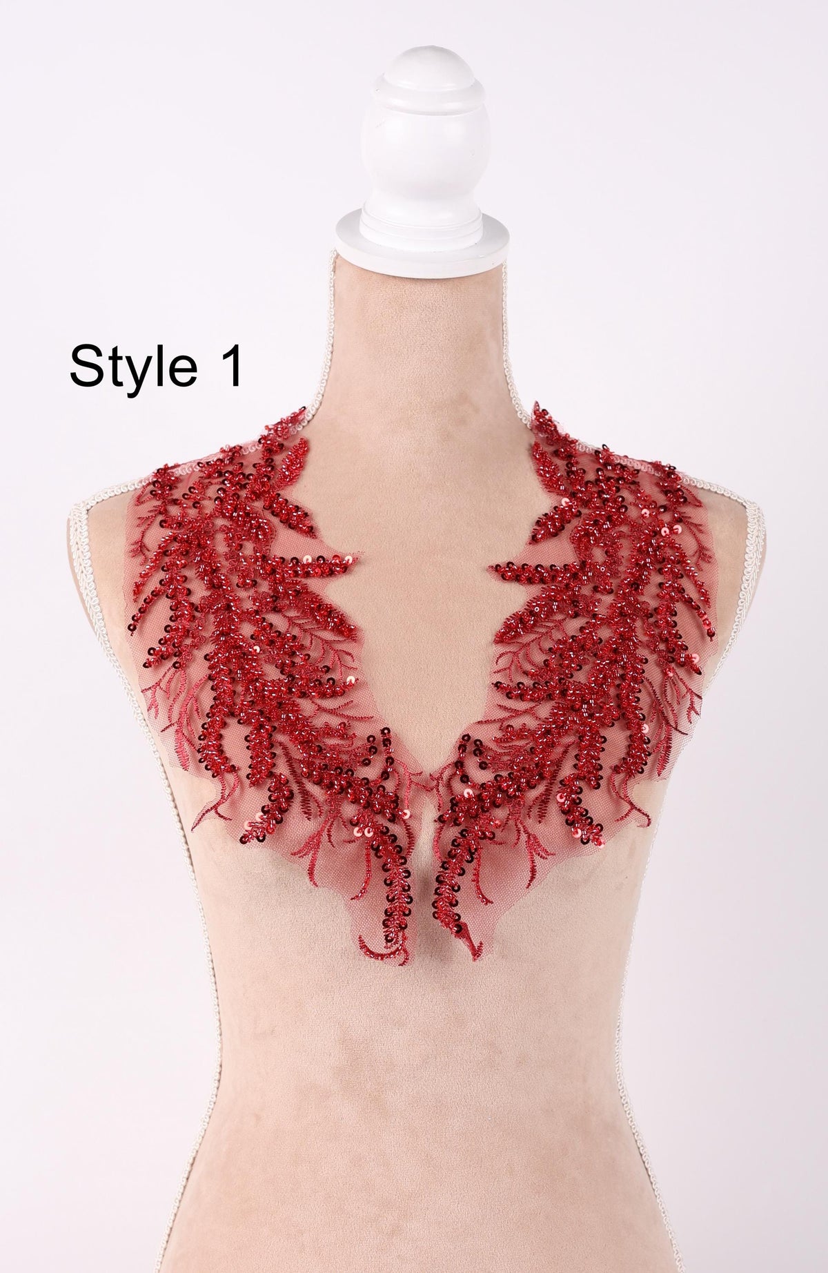 A mannequin wearing a red sequined neckline with a floral pattern.