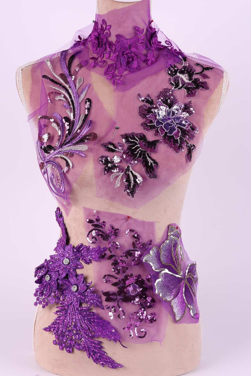a dress with purple and black floral embroidery, including purple flowers and black leaves, creating a visually striking and intricate design.