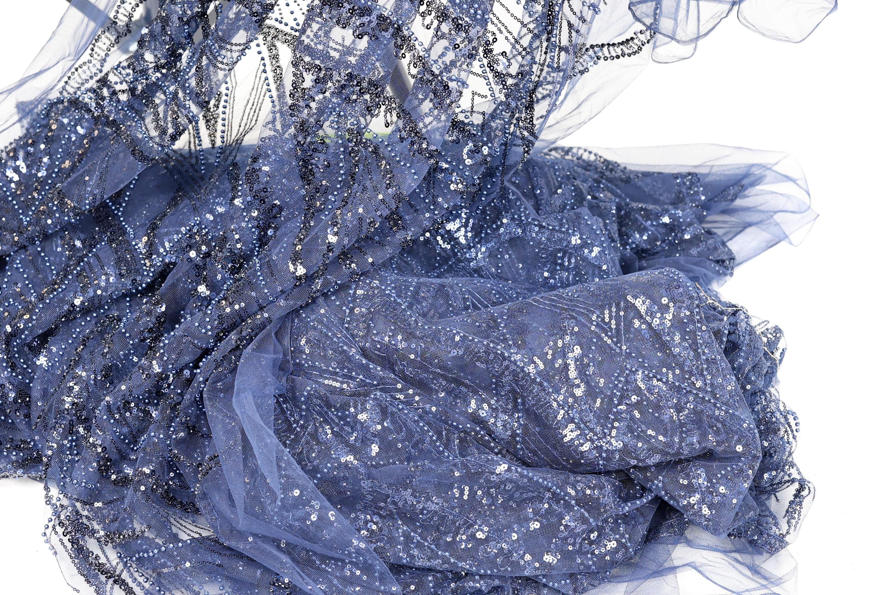 a close-up view of a piece of blue fabric with a sparkling, sequined texture.