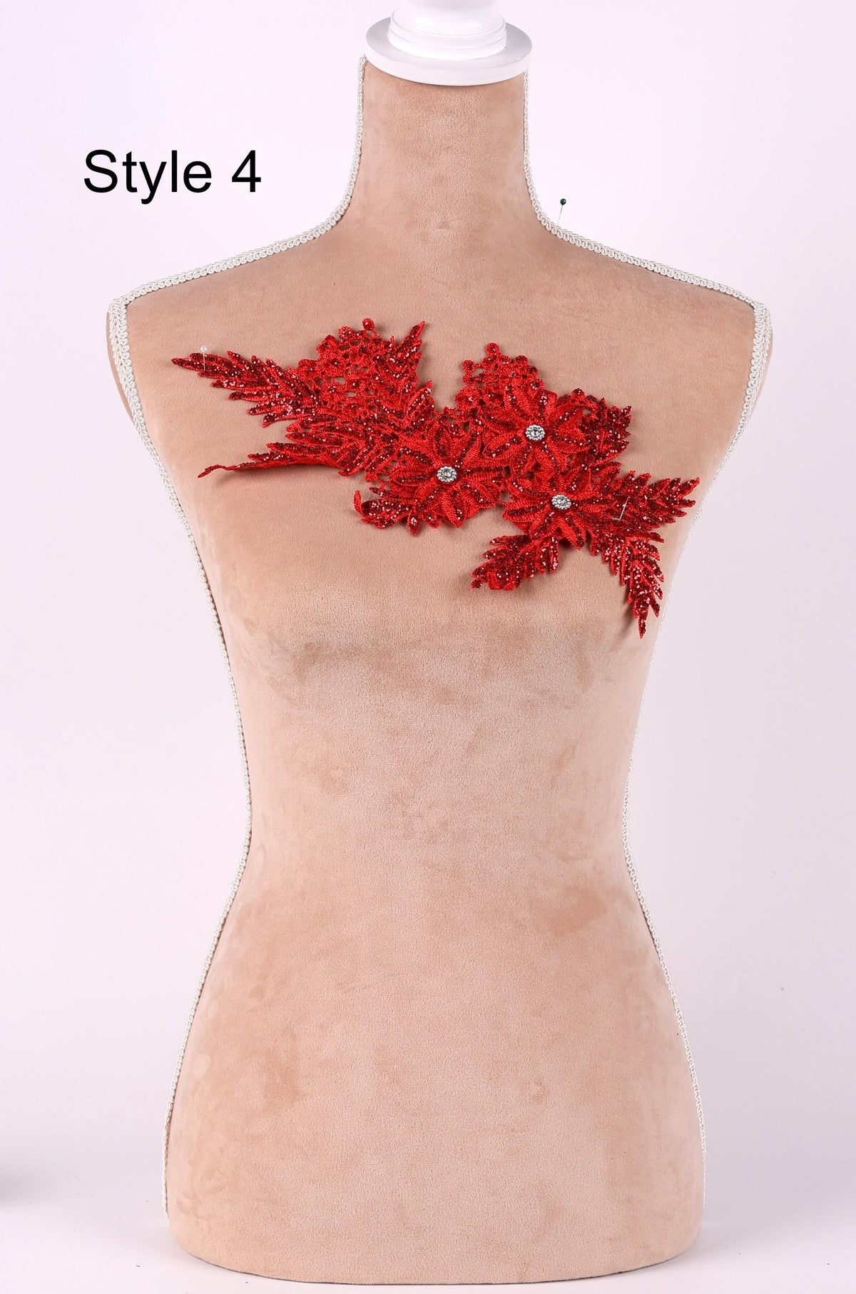 A mannequin with a red floral embroidered on its bust.