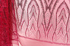 a close-up view of a fabric with a pink and red pattern, featuring a repeating design of leaves and flowers. The fabric appears to be made of a sheer material, with a delicate and intricate design.