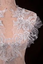 a white wedding dress with a sheer back
