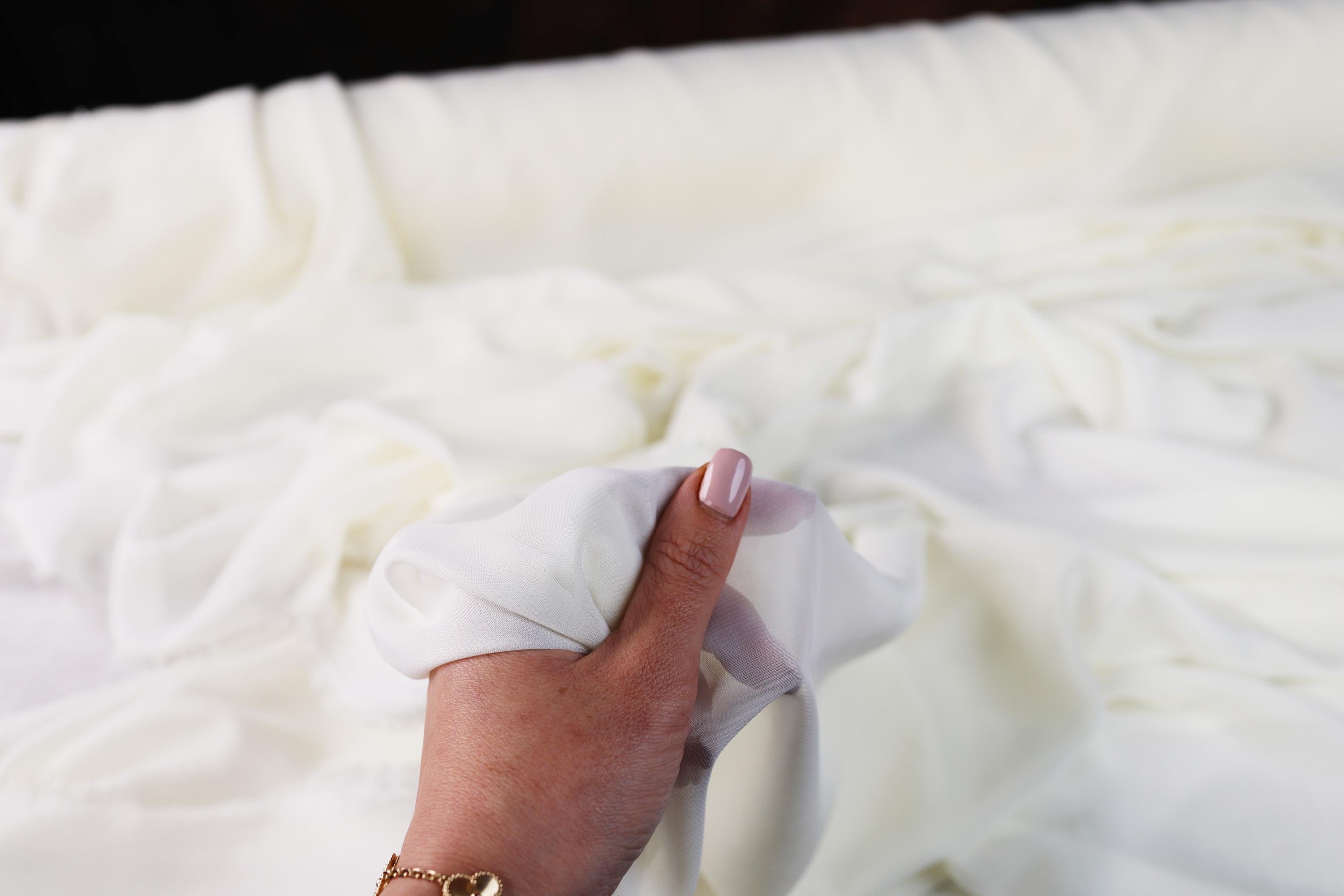 a woman&#39;s hand holding a napkin over a bed
