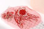 a pink fabric with red and white floral designs, including a large red flower and smaller red flowers, as well as some red and white decorative elements.