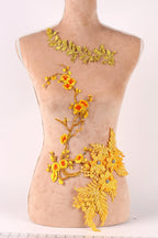 A mannequin torso with gold embroidered flowers and leaves on it, displayed on a mannequin bust form.