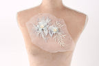 A mannequin torso with a delicate floral embroidered piece of fabric attached to it.