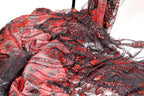 a close-up view of a fabric with a striking pattern of red and black sequins and beads. The fabric appears to be a sheer material, with a mix of black and red colors. The pattern is intricate and detailed, with the sequins and beads adding a touch of sparkle and glamour to the fabric.