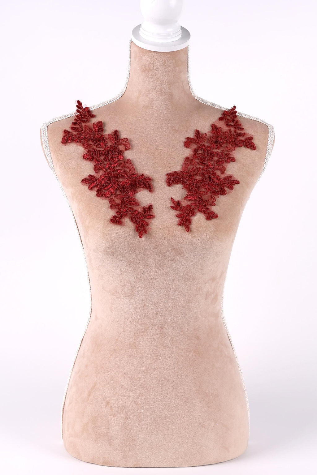 A mannequin with red embroidered flowers on its bust area.