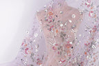 a delicate, sheer fabric with a floral pattern. The fabric is adorned with small, colorful flowers and leaves, creating a visually appealing and intricate design. The fabric appears to be made of sheer material, which adds a soft and delicate touch to the overall appearance.