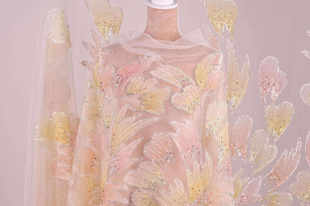 a mannequin wearing a dress with a floral pattern of pink and yellow flowers. The dress appears to be made of sheer fabric, giving it a delicate and elegant appearance.