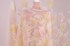a mannequin wearing a dress with a floral pattern of pink and yellow flowers. The dress appears to be made of sheer fabric, giving it a delicate and elegant appearance.