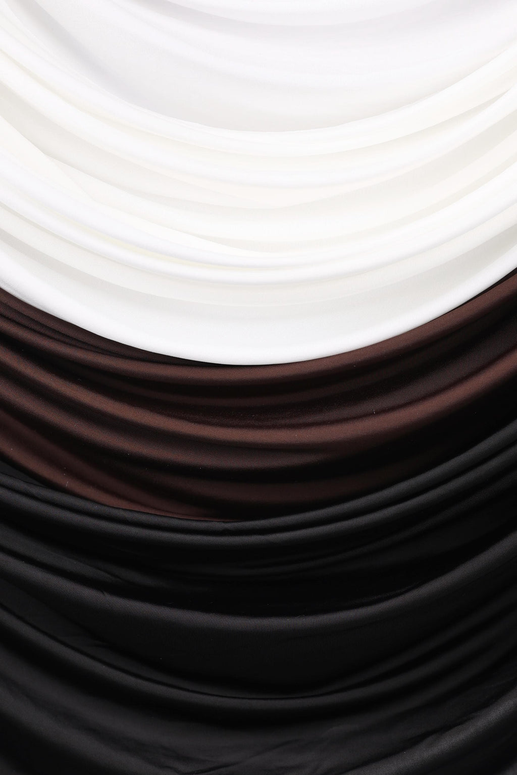 a close-up view of a fabric with a textured surface, consisting of three distinct colors: white, brown, and black.