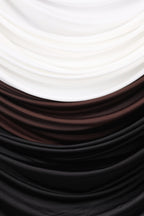 a close-up view of a fabric with a textured surface, consisting of three distinct colors: white, brown, and black.