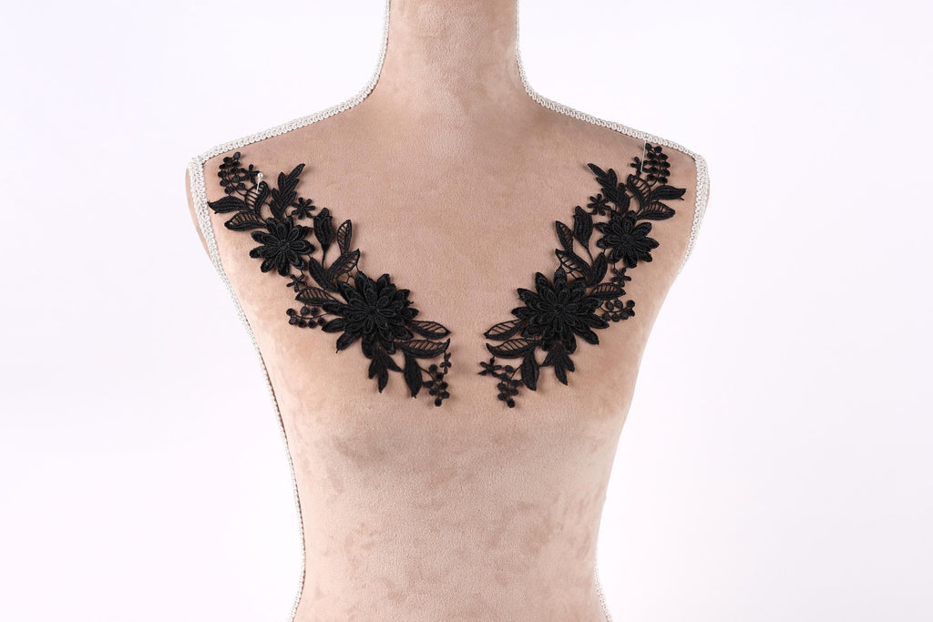 A mannequin with a beige body and black floral embroidery on the bust area.