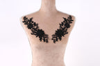 A mannequin with a beige body and black floral embroidery on the bust area.