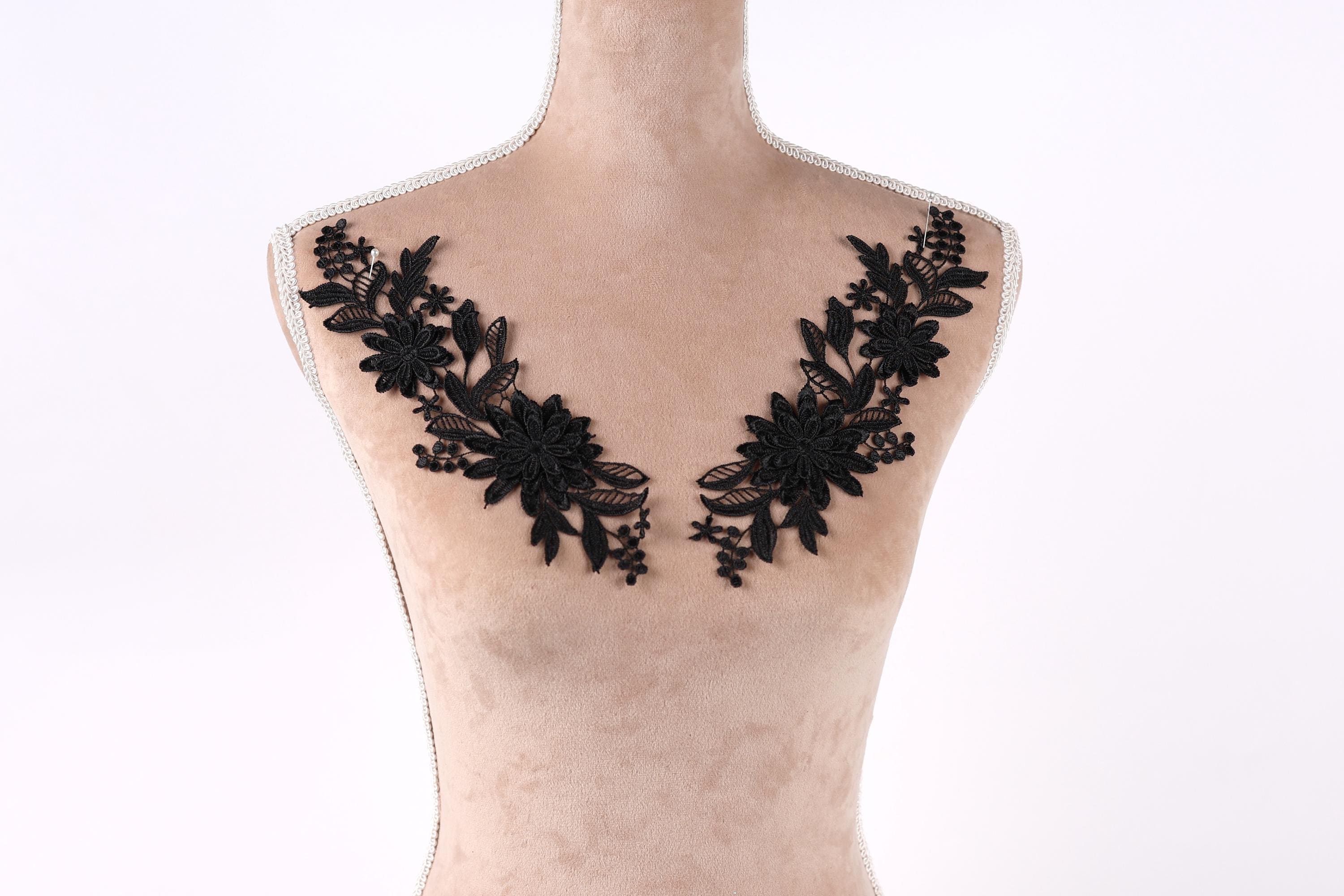 A mannequin with a beige body and black floral embroidery on the bust area.